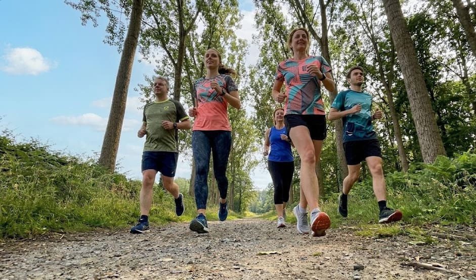 Groupe de coureurs amateurs sur un sentier nature au lever du soleil