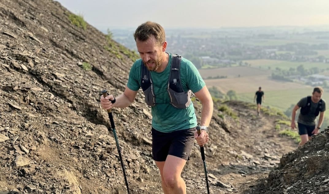 Coureur amateur sur sentier de trail en montagne à la lumière dorée du matin