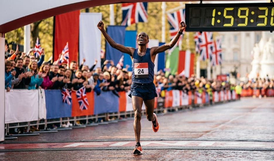 Coureur marathon élite franchissant la ligne d'arrivée à Londres en lumière dorée